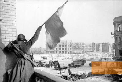 Image: Stalingrad, January 1943, A Soviet flag being waved at the central square in Stalingrad, Bundesarchiv, Bild 183-W0506-316