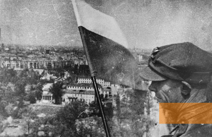 Image: Berlin, May 2 1945, A soldier of the Polish People's Army waves the Polish flag atop the Victory Column, public domain