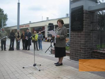 Bild:Königsberg, 2011, Die Überlebende Nechama Drober spricht bei der Einweihung der Gedenktafel, im Hintergrund der Eingang des Bahnhofs, Stiftung Denkmal