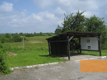 Bild:Königsgut, 2010, Informationstafel, dahinter das ehemalige Lagergelände, Stiftung Denkmal
