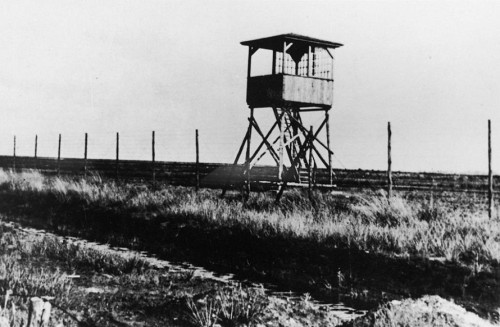 Westerbork, o.D., Stacheldraht und einer der sieben Wachtürme des Lagers, Herinneringscentrum Kamp Westerbork/NIOD