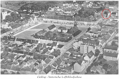 Goldap, o.D., Luftaufnahme vom Marktplatz – der Standort der Synagoge ist markiert, Kreisgemeinschaft Goldap e. V.