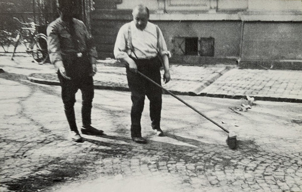 Neustadt, 1933, Gustav Weil wird unter Aufsicht eines SA-Mannes zum Kehren der Maximilianstraße in Neustadt gezwungen, Stadtarchiv Neustadt/Weinstraße, Sammlung GB 623